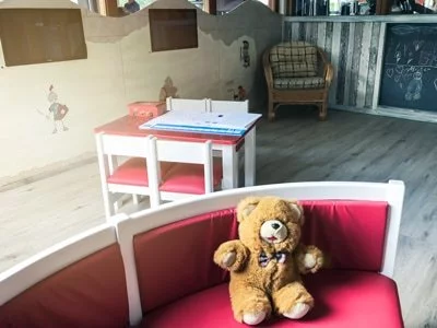 Ferdy's Gym Aldenhoven: Kinderbereich mit Teddybär auf roter bank